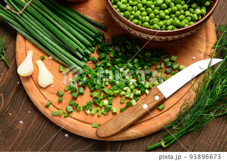 green onion, sweet peas on a dark wooden background, still life, concept of fresh and healthy food 93896673