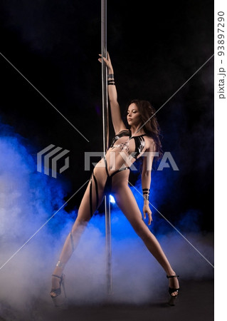 Alluring fit lady dancing near pole on stage 93897290