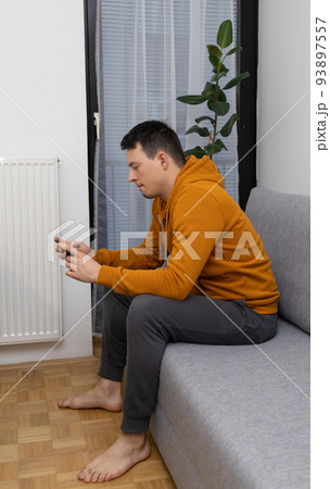 young man watching at mobile phone playing game young man watching at mobile phone playing game 93897557