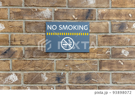 No smoking sign on the building, warning sign on the brick wall background, information about ban of smoking 93898072