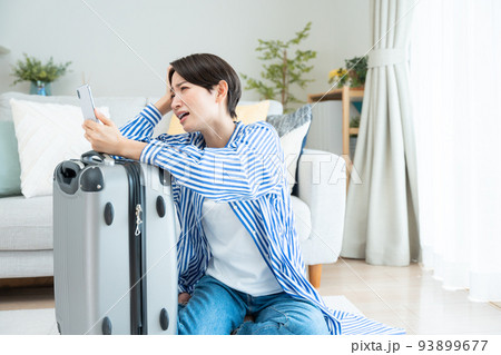旅行の準備をするミドル女性(スマホ・予約・キャンセル・問題) 旅行の準備をするミドル女性(スマホ・予約・キャンセル・問題) 93899677