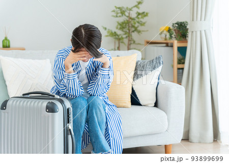 旅行の準備をするミドル女性（落ち込む・ショック・キャンセル） 93899699