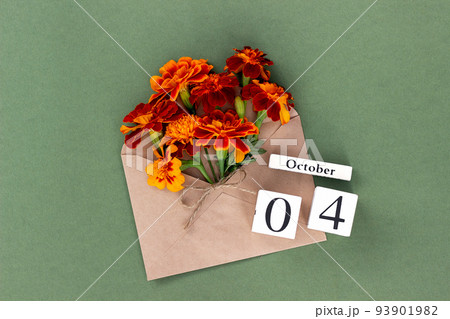 October 4. Bouquet of orange flower in craft envelope and calendar date on green background. Minimal concept Hello fall. Template for your design, greeting card 93901982