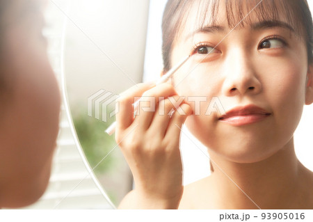 鏡を見ながらアイメイクをする若い女性 ビューティー イメージ 鏡を見ながらアイメイクをする若い女性 ビューティー イメージ 93905016
