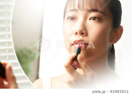 鏡を見ながらリップを塗る若い女性　ビューティー　イメージ 93905021