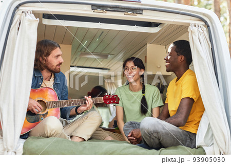 Young people playing guitar in motorhome Young people playing guitar in motorhome 93905030