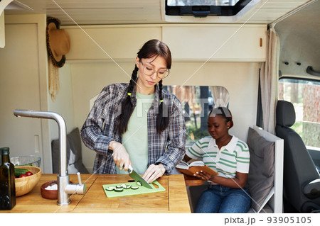 Woman cooking salad in motorhome 93905105