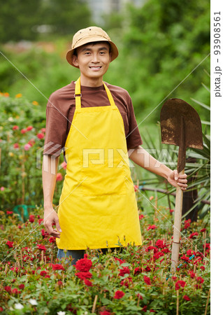 Smling garden worker digging out blooming flowers for customer 93908561