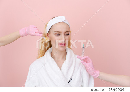 Woman chooses facial care procedure on both sides, gloved hands reach out 93909044