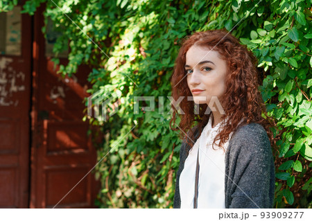 Portrait happy tender ginger girl with blue eyes and freckles looking at camera 93909277