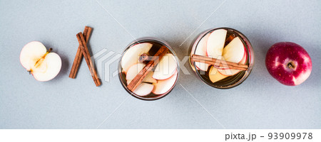 Homemade apple cider with cinnamon in glasses on a gray background. Warming winter drinks. Top view. Web banner 93909978