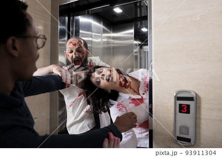 Cruel scary zombies chasing afraid man, leaving elevator to eat brain and attack office. Scared frightened person running from terrifying evil monsters with wounds, walking dead hunting. 93911304