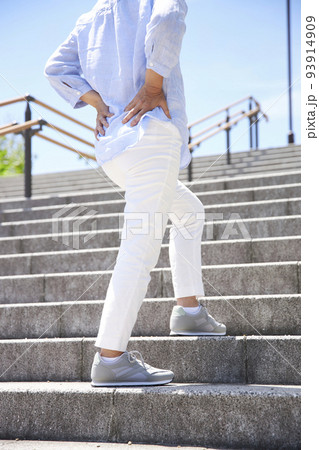 ウオーキング中に腰の痛みを感じるミドル女性 93914909