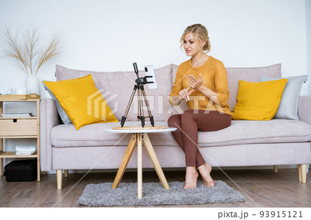 Caucasian woman blogger with notepad and talking camera live video recording Caucasian woman blogger with notepad and talking camera live video recording 93915121