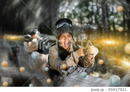 Happy girl targeting shooting with paintball marker Happy girl targeting shooting with paintball marker 93917021