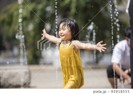 駅前広場の噴水で水浴びして遊んでいる女の子 93918555