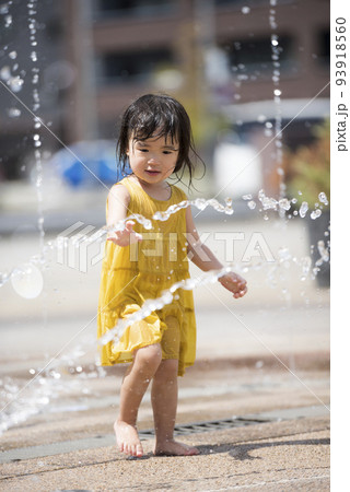 駅前広場の噴水で水浴びして遊んでいる女の子 駅前広場の噴水で水浴びして遊んでいる女の子 93918560