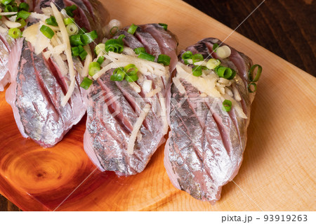 新鮮な鯵の握り寿司。ネギと生姜の薬味をトッピング。 新鮮な鯵の握り寿司。ネギと生姜の薬味をトッピング。 93919263