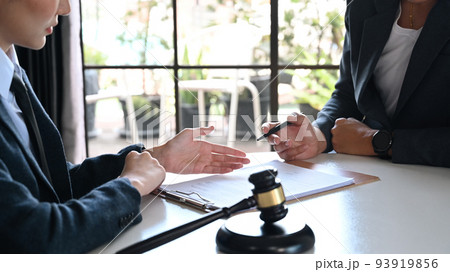 Female lawyer explaining terms, condition on legal document to client before signing on contract at law firm 93919856