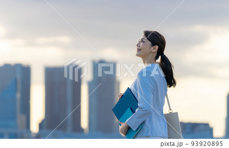 都市を背景に立つビジネスウーマン 都市を背景に立つビジネスウーマン 93920895