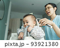 Chinese Mom cutting hair of child with hair clipper 93921380