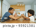 African father and son arm wrestling 93921381