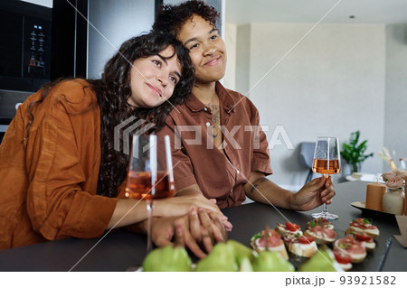 Young affectionate woman keeping head on shoulder of her girlfriend Young affectionate woman keeping head on shoulder of her girlfriend 93921582