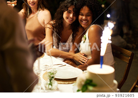 Cheerful young intercultural brides in wedding attire looking at big cake Cheerful young intercultural brides in wedding attire looking at big cake 93921605