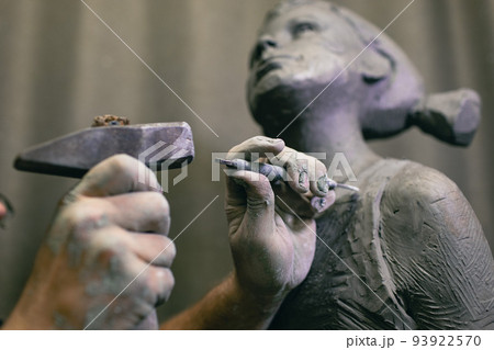 Man sculptor creates sculpt bust human woman sculpture with hammer. Statue craft creation workshop. Man sculptor creates sculpt bust human woman sculpture with hammer. Statue craft creation workshop. 93922570