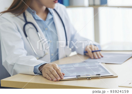 Close up hands of women doctor write prescription medical lab hospital. Crop asian women hand doctors working in medical clinic looking CAT scan xray film. Doctor with stethoscope writing on notepad 93924159