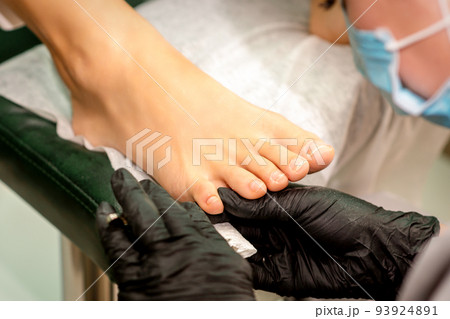 The podiatry doctor examines the toenails on the female foot The podiatry doctor examines the toenails on the female foot 93924891