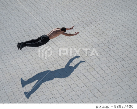 A man doing push-ups with flying outdoors. 93927400