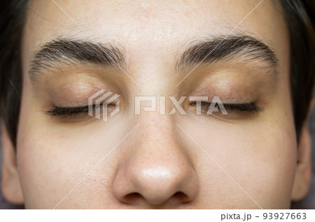 Close-up portrait of a young caucasian woman before eyelash lamination procedure.  Close-up portrait of a young caucasian woman before eyelash lamination procedure.  93927663