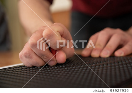 A man uses a special stencil and stylus to write a letter in braille. A man uses a special stencil and stylus to write a letter in braille. 93927936