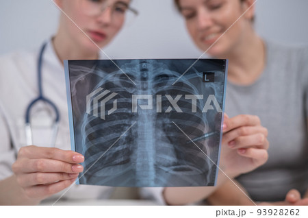 The doctor consults a caucasian woman and comments on the x-ray of the lungs. The doctor consults a caucasian woman and comments on the x-ray of the lungs. 93928262