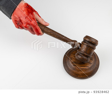 Female judge with bloody hands beats the gavel on a white background. 93928462