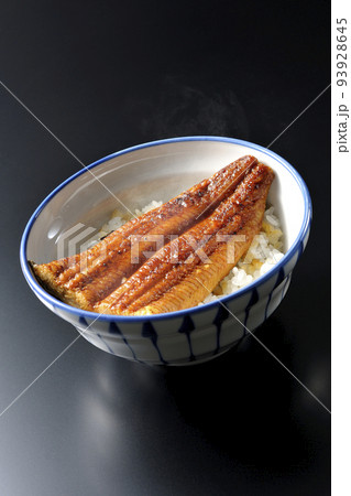 白米の上に鰻の蒲焼きが乗ってる熱々鰻丼を黒背景で撮影 93928645