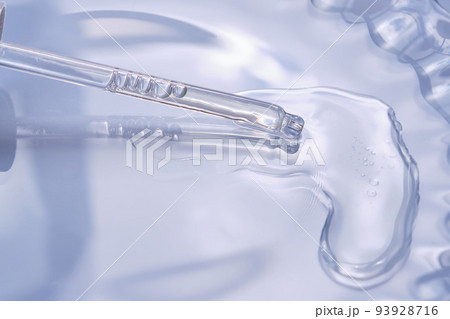 Dropper with serum or cosmetic oil on a blue background. 93928716