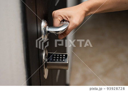 Woman opens the combination lock on the door to the apartment. Keyless entry.  93928728