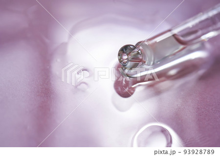 Dropper with serum or cosmetic oil on a pink background. 93928789