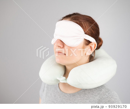 Caucasian woman with travel pillow and sleeping mask isolated on white background. Caucasian woman with travel pillow and sleeping mask isolated on white background. 93929170