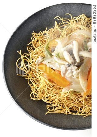 しめじや人参、玉葱などが入っている餡がかかった熱々皿うどんを白背景で俯瞰撮影 93930563