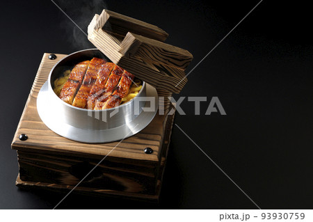 鰻の蒲焼きが入っている熱々の釜飯を黒背景で撮影 93930759