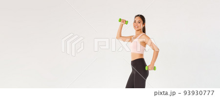 Sport, gym and healthy body concept. Full length of smiling female athlete, cute girl doing fitness exercises with dumbbells. Sportswoman in active wear workout in gym, white background 93930777