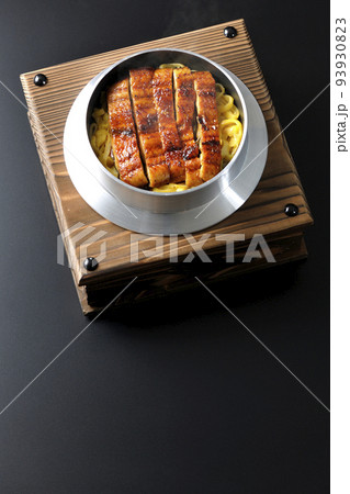 鰻の蒲焼きが入っている熱々釜飯を黒背景で俯瞰撮影 鰻の蒲焼きが入っている熱々釜飯を黒背景で俯瞰撮影 93930823