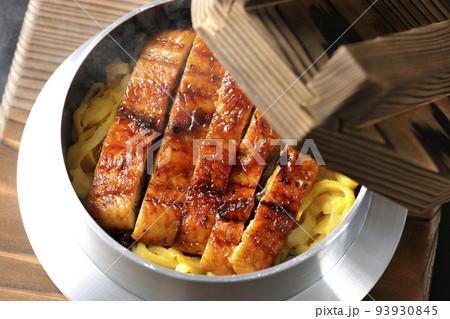鰻の蒲焼きが入っている熱々釜飯を黒背景で俯瞰撮影 93930845