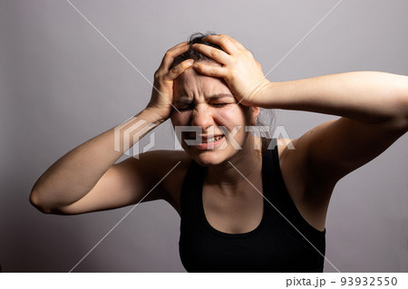 The woman grabs her head with her hands and gets angry. Family quarrels, panic attacks and fears, rage and anger, headache and trouble. The woman grabs her head with her hands and gets angry. Family quarrels, panic attacks and fears, rage and anger, headache and trouble. 93932550