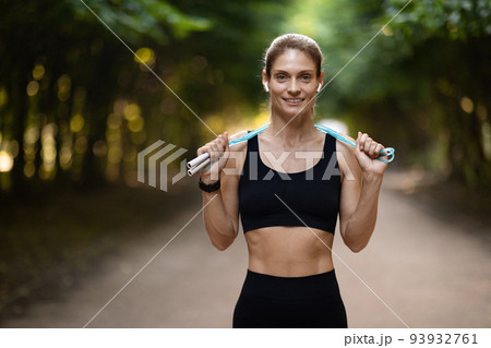 Athletic blonde woman having workout outdoors, holding jumping rope Athletic blonde woman having workout outdoors, holding jumping rope 93932761