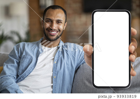 Place For Ad. Cheerful Black Man Demonstrating Blank Smartphone With White Screen 93933819