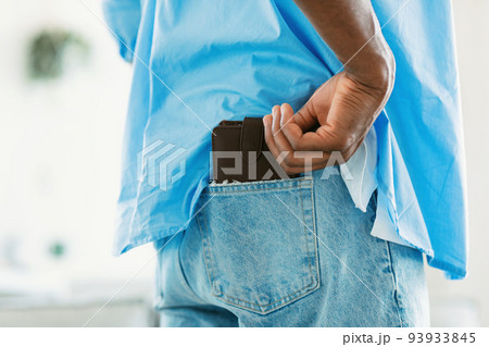 Rear view of african american man keeping wallet in back pocket of his jeans, closeup, cropped Rear view of african american man keeping wallet in back pocket of his jeans, closeup, cropped 93933845